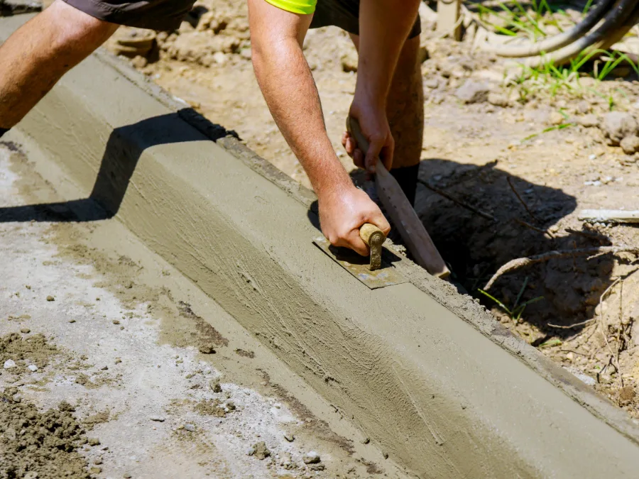 Hand-finishing a poured concrete curb with a trowel