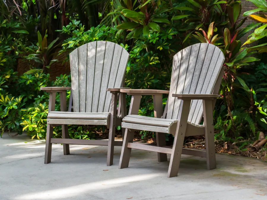 Two chairs on a smooth concrete patio against tropical planting