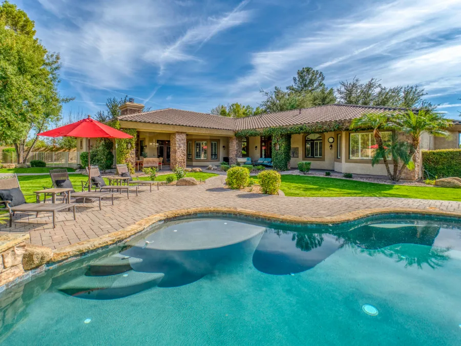 Residential pool surrounded by a poured deck and patio